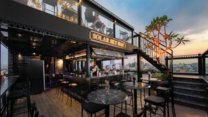 A rooftop bar with a sign reading "Solar Sky Bar," featuring outdoor seating, a bar area, and a view of the cityscape. - GM Premium Hotel  (Hanoi)