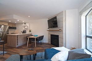 Una sala de estar moderna con sofá, mesa de centro y chimenea.