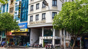 Un hôtel avec une enseigne bien visible, un café et plusieurs motos garées devant.