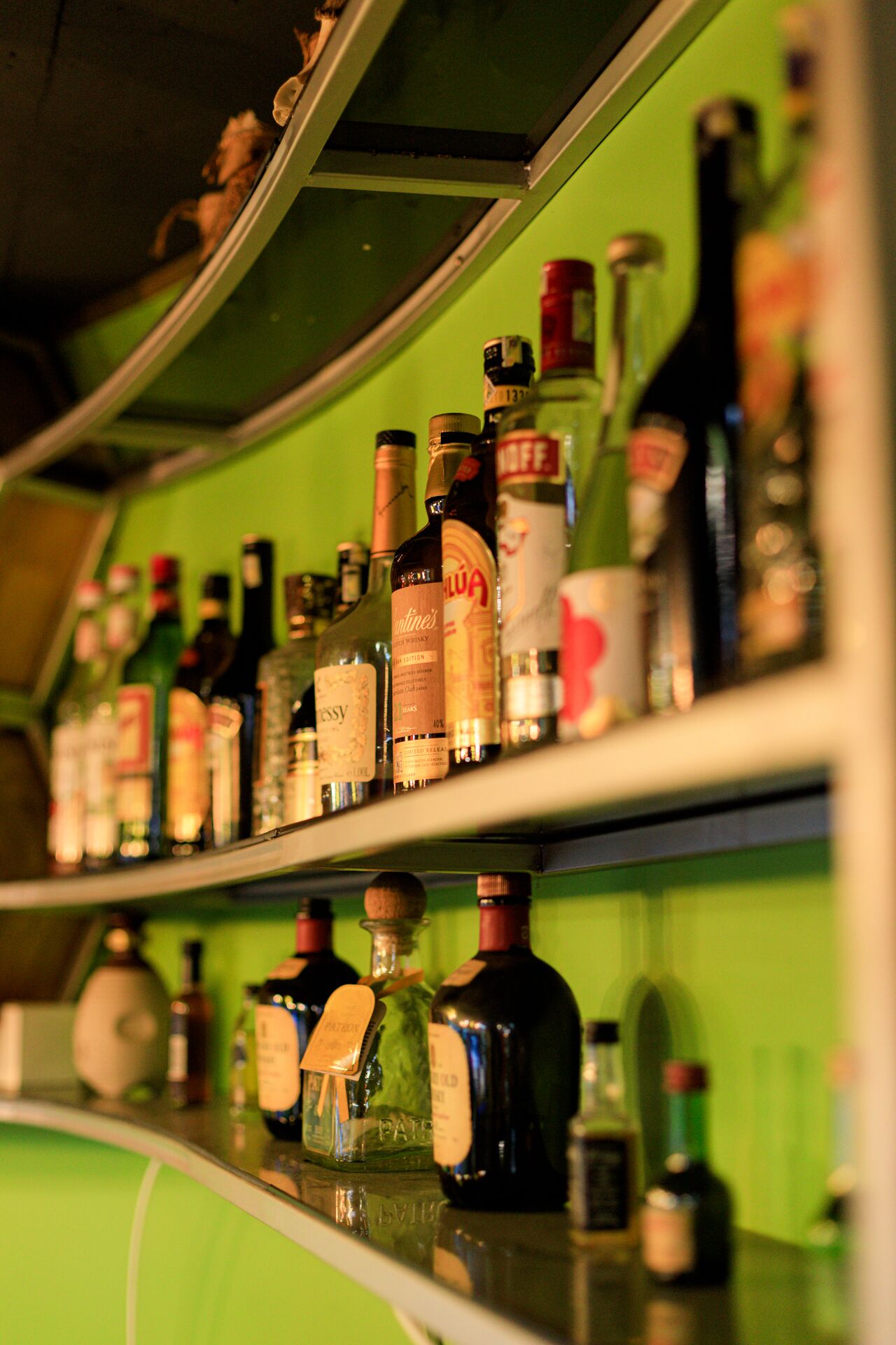 A bar with shelves stocked with various liquor bottles.
