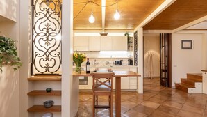 A spacious kitchen with wooden cabinets, a central island, and pendant lighting. - Apartment (Roma)