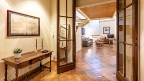 A spacious living area with a wooden staircase, a dining table, and a sofa. - Apartment (Roma)