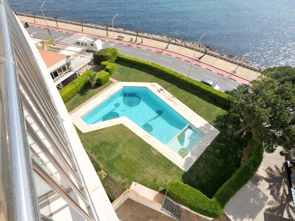 A swimming pool with a unique design, surrounded by well-maintained hedges and a view of the sea. - apartment with seaview in Riells (l'Escala)