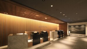 A modern reception area with wooden paneling and a marble reception desk. - JR WEST GROUP VIA INN PRIME AKASAKA (Tokyo)