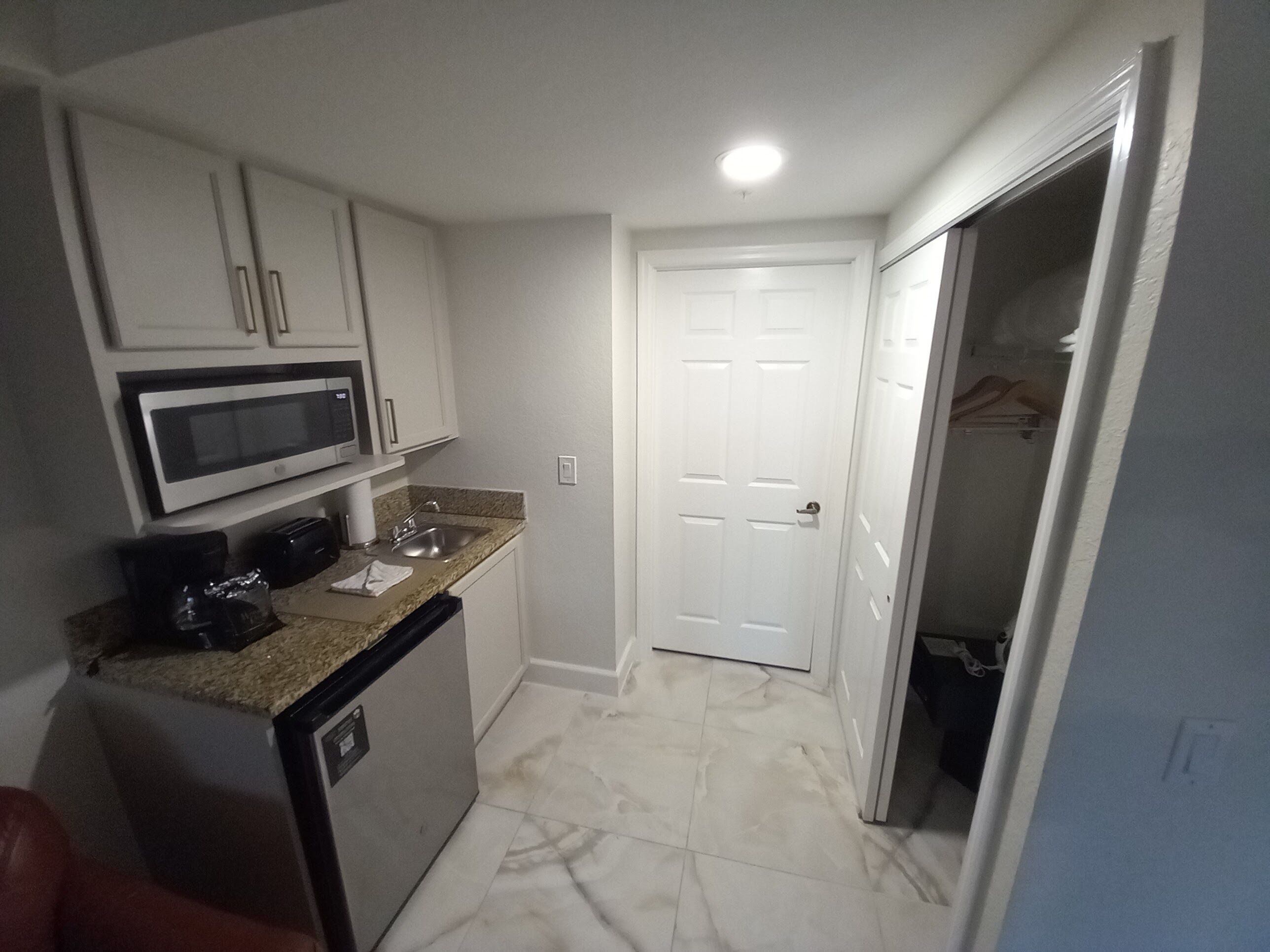 A compact kitchen with a microwave, sink, and dishwasher.