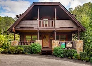 A two-story lodge with a balcony, stone foundation, and a front porch. - Hillside Dreams #265 (Sevierville)