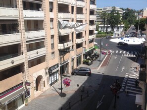 Ein mehrgeschossiges Gebäude mit Balkonen, Geschäften und Blick auf die Straße.