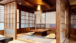 A traditional Japanese room with tatami flooring, a low wooden table, and sliding shoji doors.