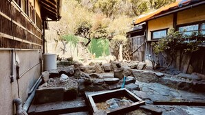 A rustic courtyard with stone structures and a small water feature.