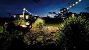 Una casa al anochecer con luces colgantes en el jardín.