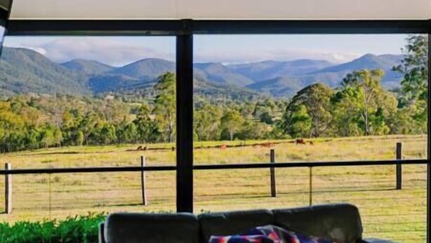 Una habitación con un amplio ventanal que ofrece vistas a un paisaje montañoso.