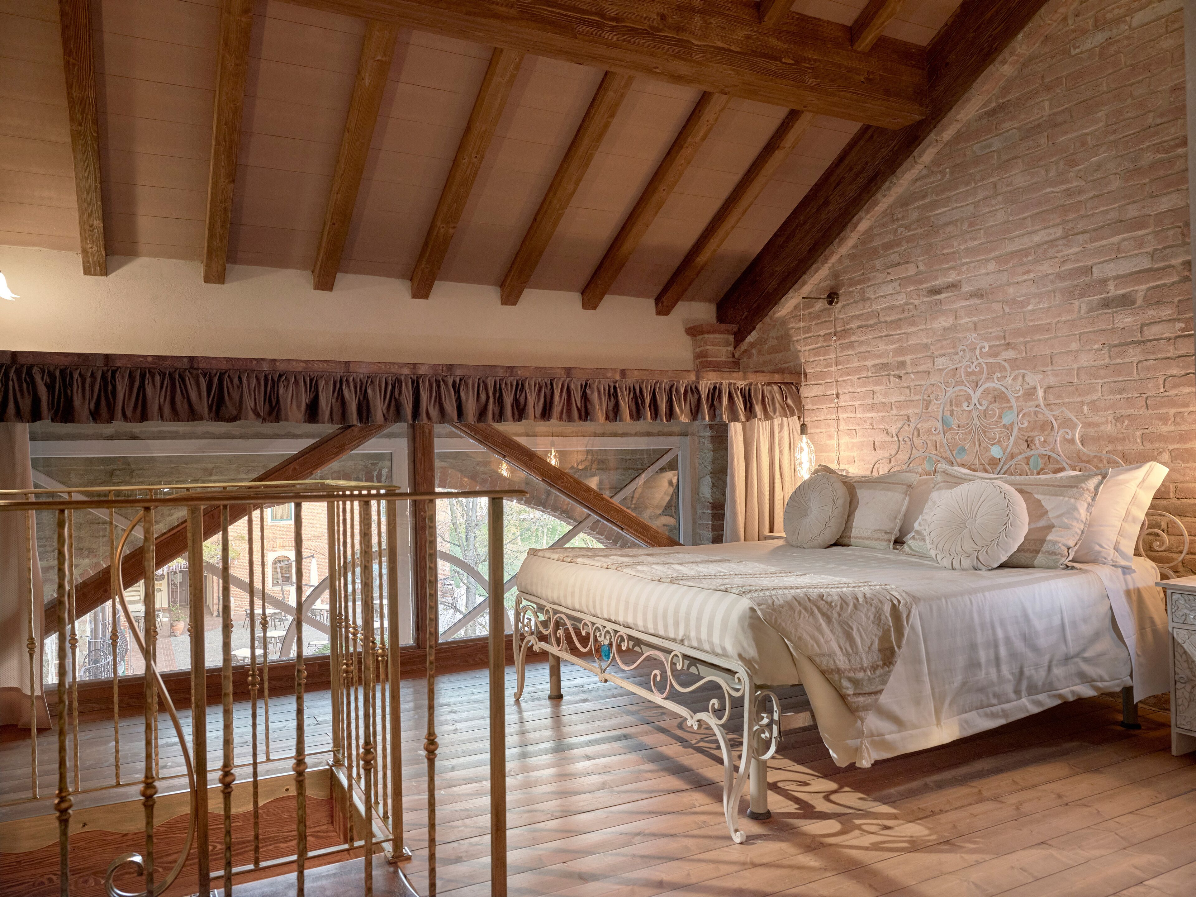 A bedroom with a bed, a window, and a staircase.