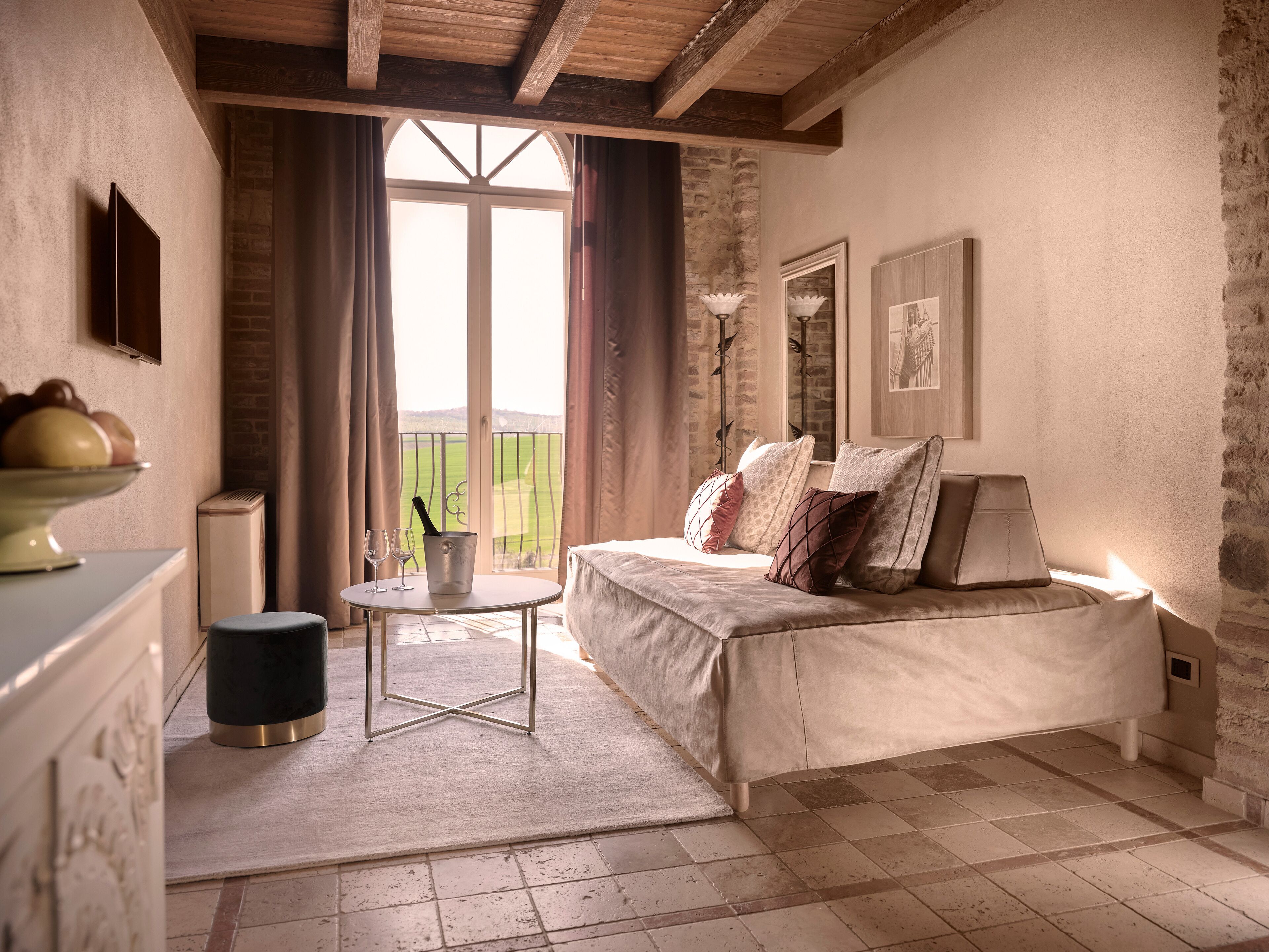 Un dormitorio acogedor con cama, mesita de noche y vistas a un paisaje verde a través de una ventana.