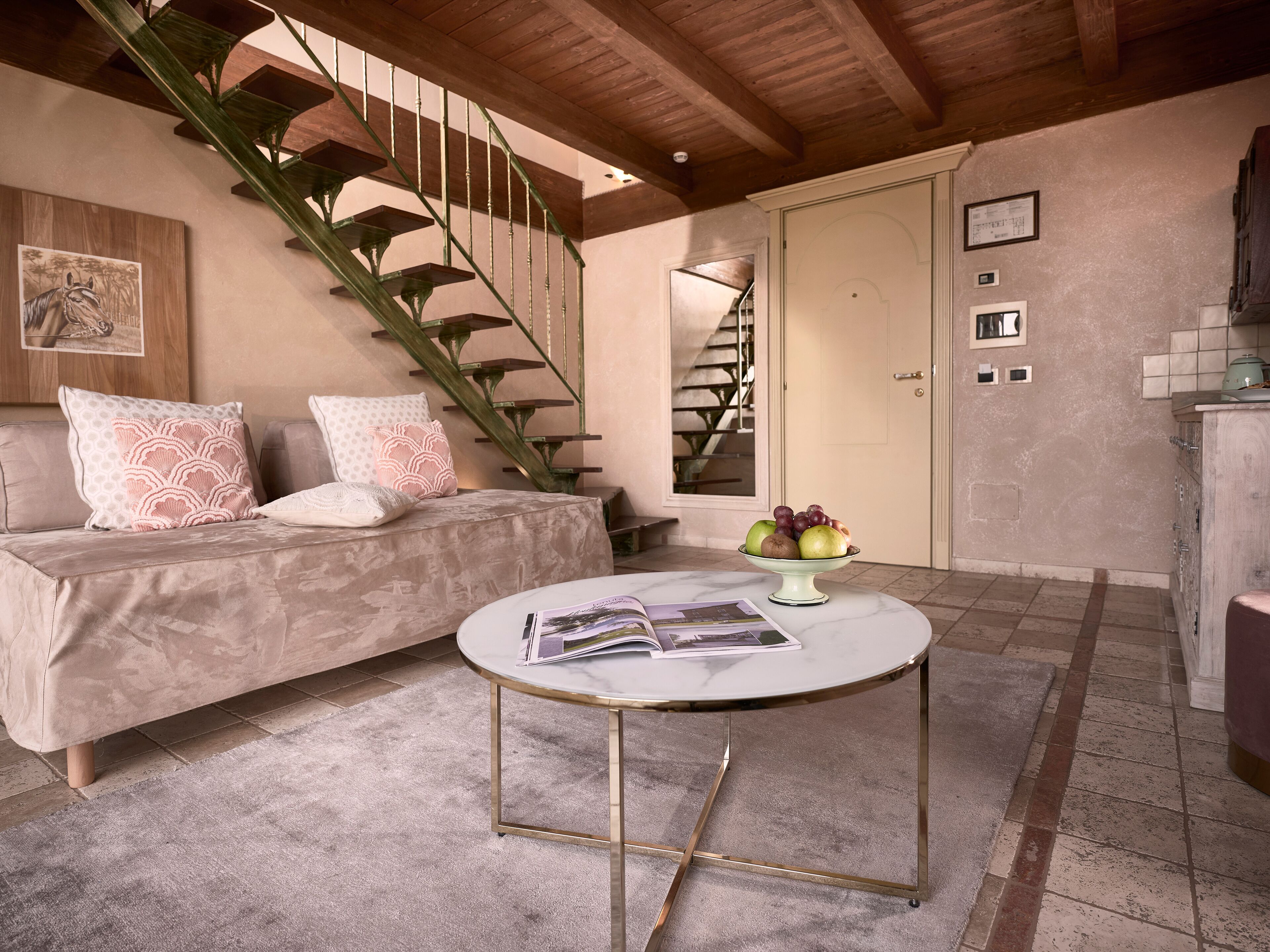 Una sala de estar acogedora con un sofá, una mesita de centro y una escalera.