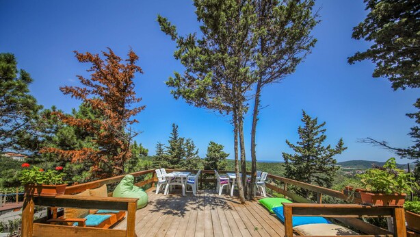 A wooden deck with outdoor seating, surrounded by trees and a clear view of the landscape. - Agva Green Blue Otel (Sile)
