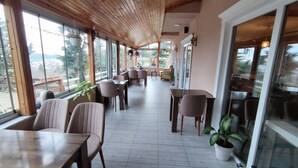A spacious indoor area with wooden ceiling and large windows, featuring multiple seating arrangements and potted plants. - Agva Green Blue Otel (Sile)