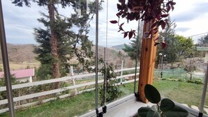 A room with a large window offering a view of a fenced yard with trees and a distant landscape. - Agva Green Blue Otel (Sile)