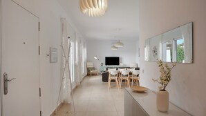 Ein modernes Interieur mit Essbereich, Fernseher und großem Spiegel.