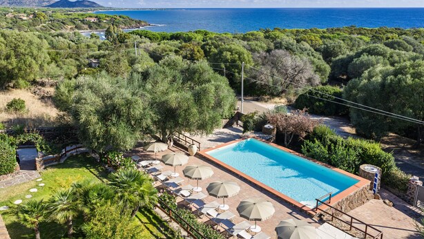 A pool with umbrellas, surrounded by greenery and a view of the sea. - Holiday Apartment 'mamuthones' with Sea View, Wi-Fi, Terrace & Shared Pool (Orosei)