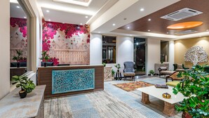 A spacious lobby with a reception desk, seating area, and decorative elements.