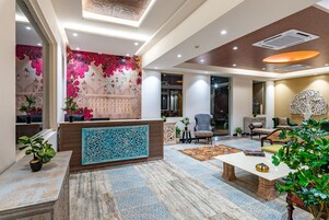 A spacious lobby with a reception desk, seating area, and decorative elements.