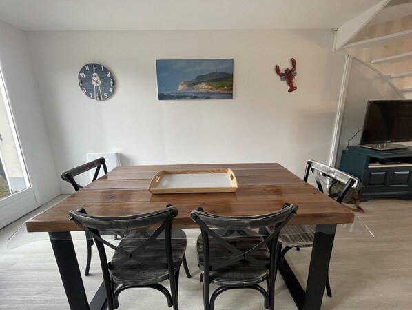 A dining area with a wooden table, four chairs, a tray, a clock, a painting, and a lobster decoration. - House with an ocean view for 6 people (Audinghen)