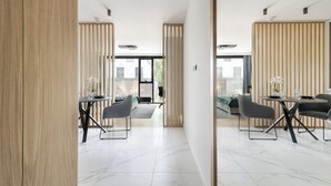 Un comedor moderno con una mesa redonda, dos sillas y vistas al exterior a través de amplias ventanas.