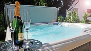 Een bubbelbad met twee champagneglazen en een fles.