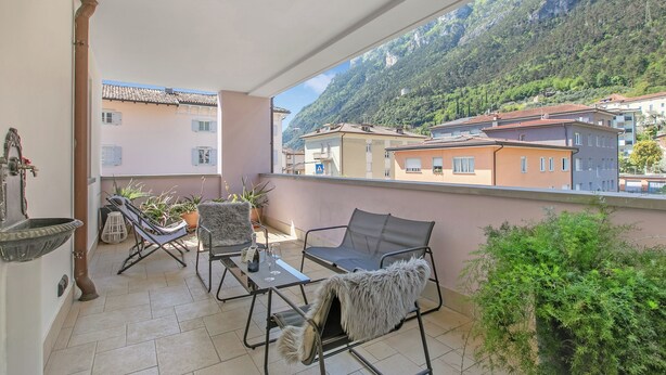 Ein Balkon mit Tisch, Stühlen und einem Blumentopf.