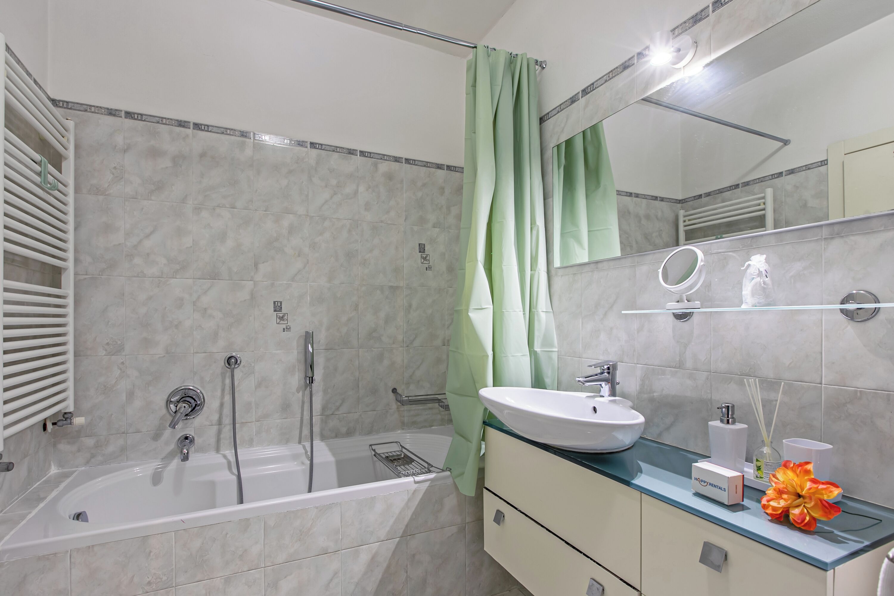Une salle de bain moderne équip ée d’une baignoire, d’une douche, d’un meuble-lavabo et d’un miroir.