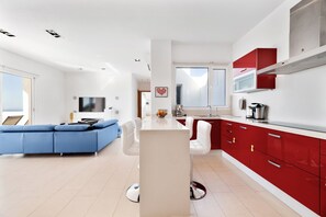 A modern apartment with a living area, kitchen, and dining space.