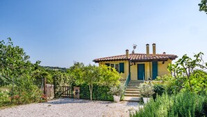 A yellow villa with a tiled roof, surrounded by a gravel driveway and lush greenery. - APARTMENT 6 PEOPLE IN COUNTRY VILLA WITH POOL (Lame)