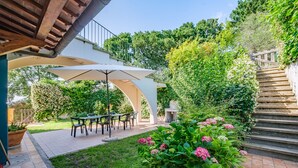 An outdoor patio with a covered seating area, a stone staircase, and lush greenery. - APARTMENT 6 PEOPLE IN COUNTRY VILLA WITH POOL (Lame)