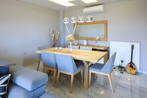 A dining area with a wooden table, blue upholstered chairs, and a mirror above the table.