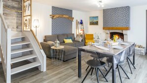 A modern living room with a staircase, a fireplace, and a dining area. - Charming house in Granville with garden and terrace (Granville)
