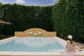 A swimming pool with a stone wall and three built-in water features. - Chiostro dei Domenicani (Lecce)