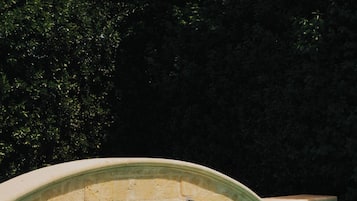 Una piscina al aire libre de temporada, sombrillas