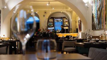 Interior de un restaurante con barra, mesas y sillas.