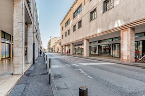 Una calle con edificios, un paso de peatones y una señal de no estacionamiento.