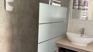 A bathroom with a white sink, a mirror, and storage shelves. - Charming City-Center Apartment with Modern Amenities and Nearby Attractions (Bar-le-Duc)