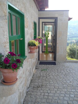 Traditional architecture meets modern charm at this stone building, featuring a paved entrance and a glass door.