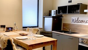 Eine moderne Küche mit Holztisch, Barhocker und Kücheninsel.