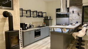 Una cocina moderna con una isla central, estufa integrada y refrigerador.