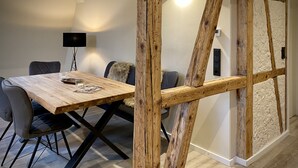A dining area with a wooden table, chairs, and a modern lamp. - App. 4 - wohlBleben (4 Zi, 6 Pers.) (Braunlage)