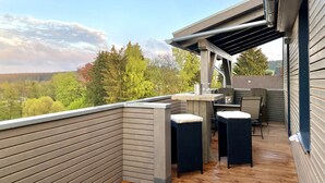 A deck with a wooden railing, a table, and two chairs. - App. 4 - wohlBleben (4 Zi, 6 Pers.) (Braunlage)
