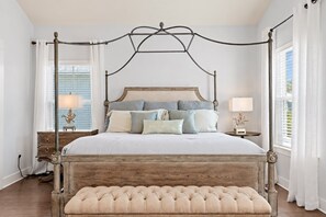 Ein Bett mit Himmelbettgestell aus Holz und eine gepolsterte Sitzbank am Fußende.