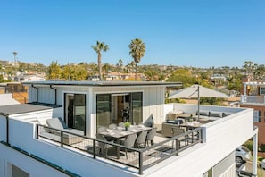 A modern rooftop terrace with a dining area, outdoor seating, and a view of the surrounding neighborhood. - Ocean Views - Jacuzzi - Rooftop Deck-walk to beach (San Diego)