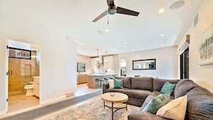 A modern living room with a sofa, coffee table, and a ceiling fan.