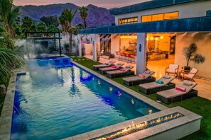 A modern outdoor pool area with lounge chairs, a bar, and a dining area. - New Custom Home built 2022 in the HEART of Old Town  (La Quinta)