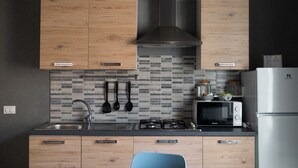Una cocina moderna con armarios de madera, una campana extractora de acero inoxidable, microondas y refrigerador.